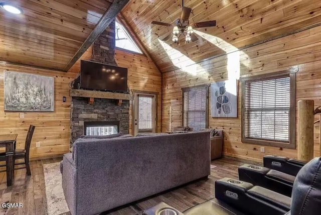 living room featuring a stone fireplace, wood walls, wood ceiling, and hardwood / wood-style flooring