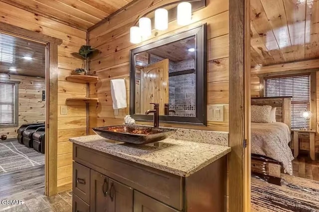 bathroom featuring vanity, wood finished floors, wood ceiling, ensuite bathroom, and wood walls