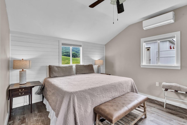 bedroom featuring hardwood / wood-style floors, ceiling fan, an AC wall unit, and lofted ceiling