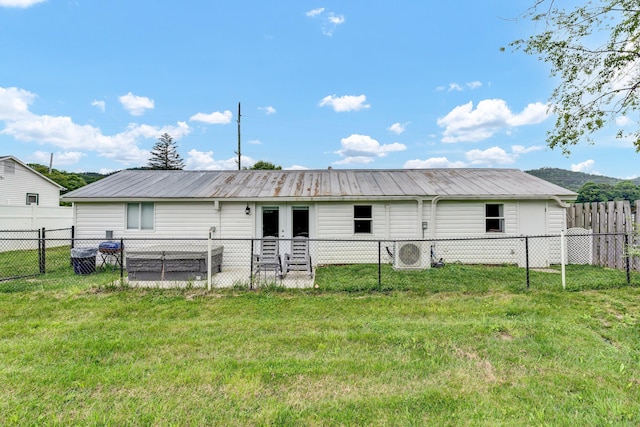 rear view of house featuring a mountain view and a yard