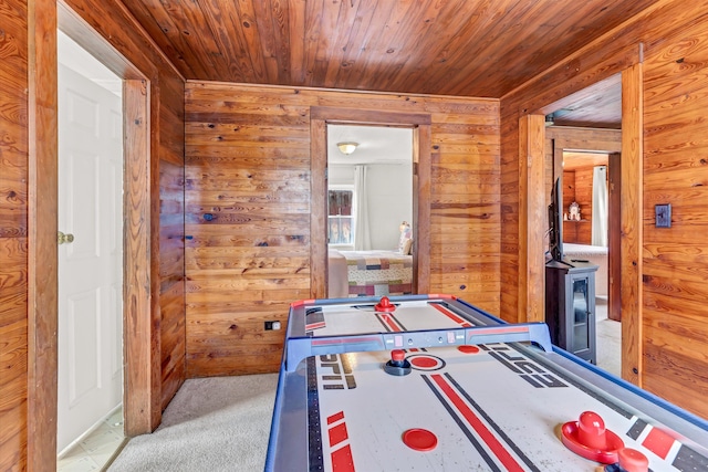 recreation room featuring light colored carpet, wood ceiling, and wooden walls