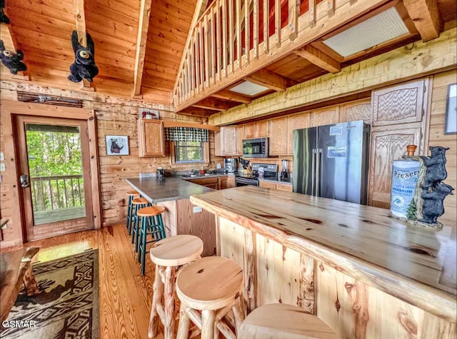 2438 Walnut Ridge Way, Sevierville, TN 37862 - kitchen with high end fridge, electric stove, light wood-style floors, plenty of natural light, and wood walls