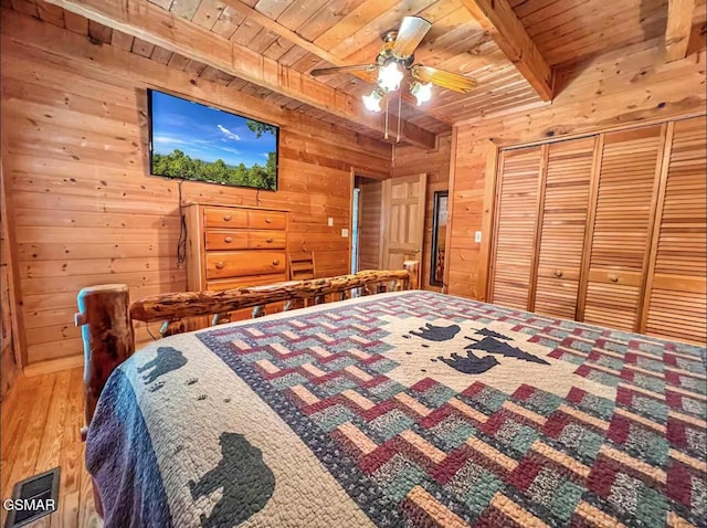 2438 Walnut Ridge Way, Sevierville, TN 37862 - bedroom with a wooden ceiling with exposed beams, wood walls, wood finished floors, a closet, and a ceiling fan