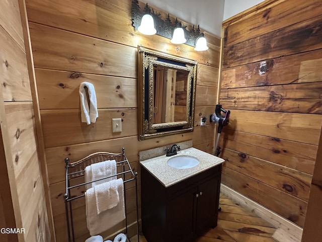 bathroom featuring wood walls and vanity