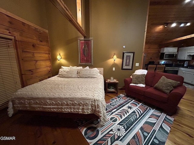bedroom featuring wood finished floors and a high ceiling