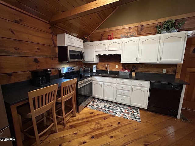 kitchen featuring lofted ceiling with beams, a sink, dark countertops, white cabinetry, and stainless steel appliances