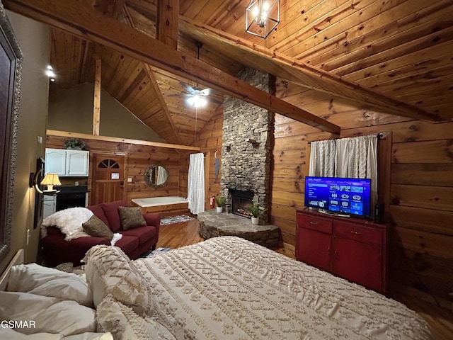 bedroom with wooden ceiling, a stone fireplace, wooden walls, wood finished floors, and vaulted ceiling with beams
