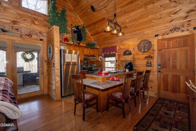 dining room with sink, wood ceiling, high vaulted ceiling, wooden walls, and dark hardwood / wood-style floors