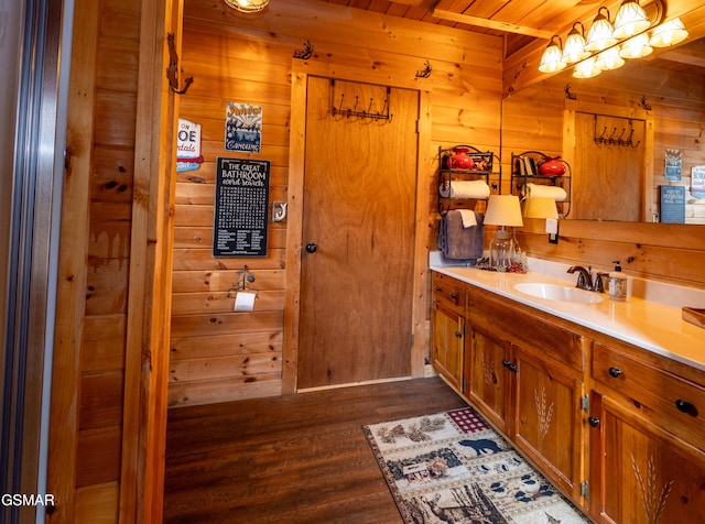 bathroom featuring vanity, wooden walls, wooden ceiling, and wood-type flooring