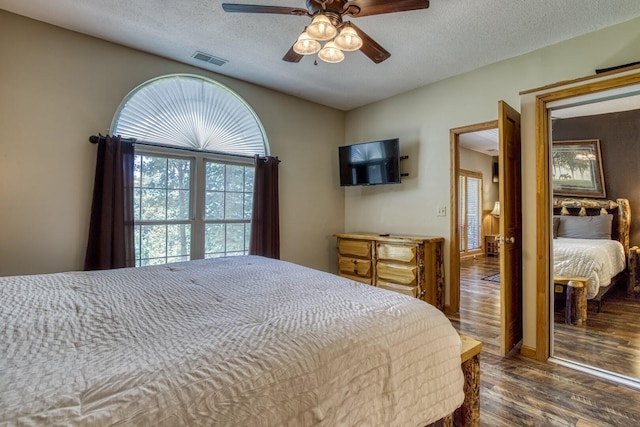 bedroom featuring a textured ceiling, ceiling fan, and dark wood-type flooring