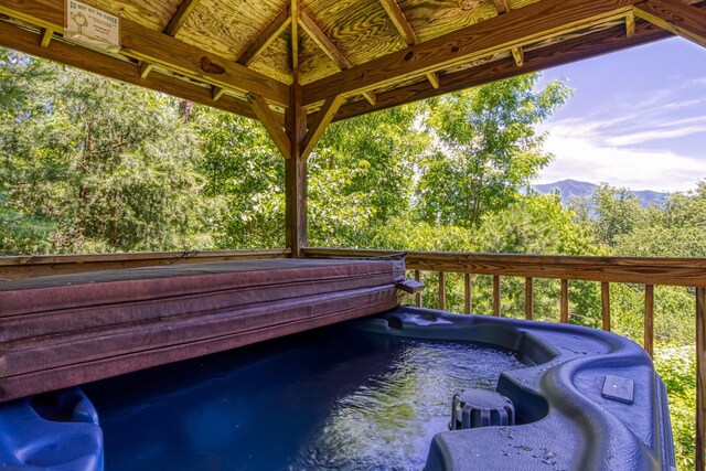 view of pool with a mountain view and a hot tub