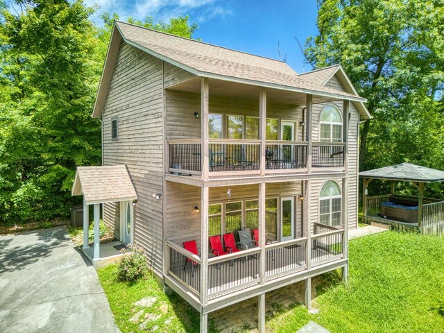 back of property with a balcony and a yard