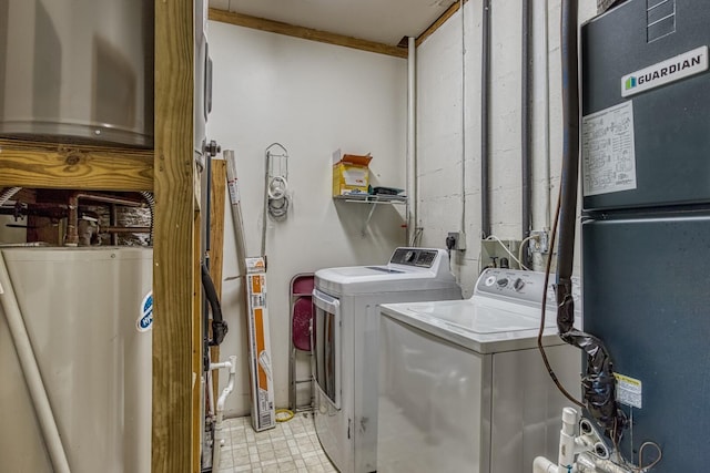 laundry room with heating unit, washing machine and dryer, and water heater