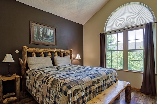 bedroom featuring a textured ceiling, dark hardwood / wood-style floors, and vaulted ceiling