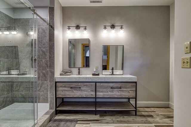 bathroom with vanity, a shower with shower door, and wood-type flooring