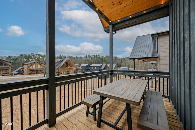 wooden terrace featuring a residential view and outdoor dining space