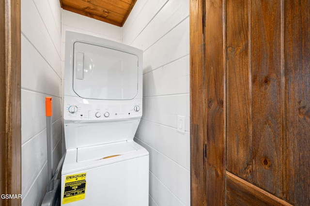 washroom with stacked washer and dryer and laundry area