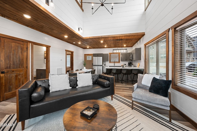 living area with wood ceiling, light wood-style flooring, a notable chandelier, and recessed lighting