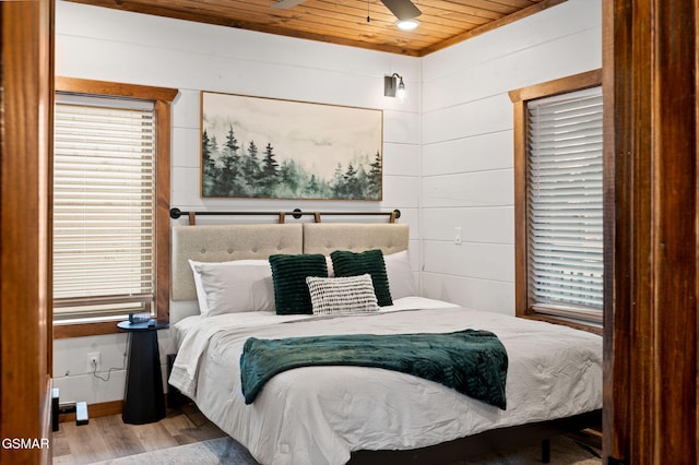 bedroom with light wood-type flooring, wood ceiling, and multiple windows