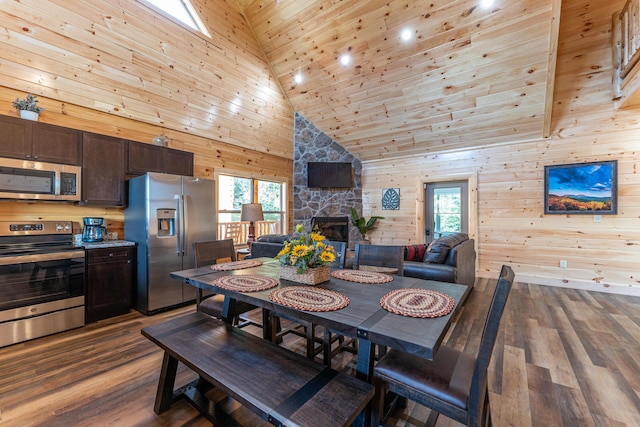 dining space featuring wooden walls, hardwood / wood-style flooring, wood ceiling, and high vaulted ceiling