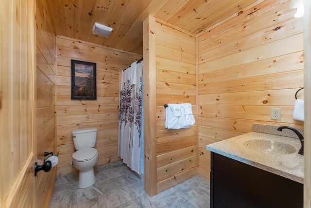 bathroom with vanity, toilet, wood walls, and wood ceiling