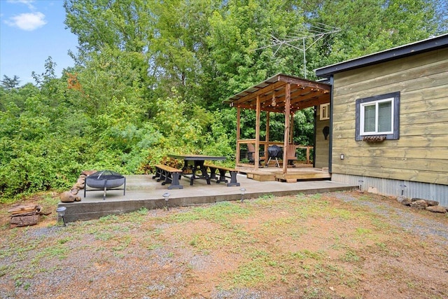 view of yard with a deck, an outdoor fire pit, and a patio area