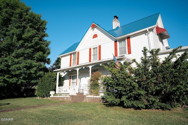 view of front facade with a front yard and covered porch