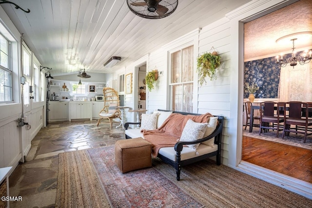 sitting room featuring ceiling fan with notable chandelier