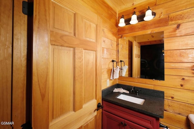 bathroom with vanity and wooden walls