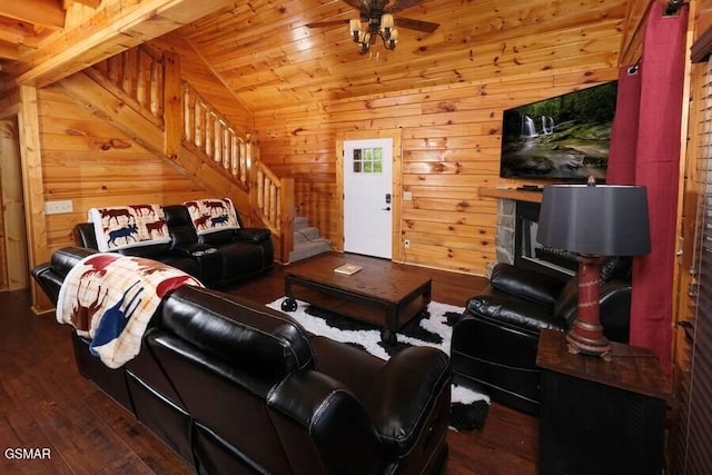 living area with a ceiling fan, vaulted ceiling, wood walls, hardwood / wood-style floors, and stairs