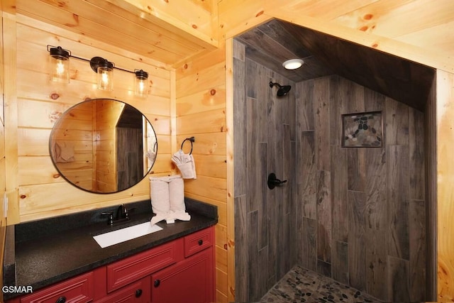 bathroom with wood walls, a tile shower, and vanity