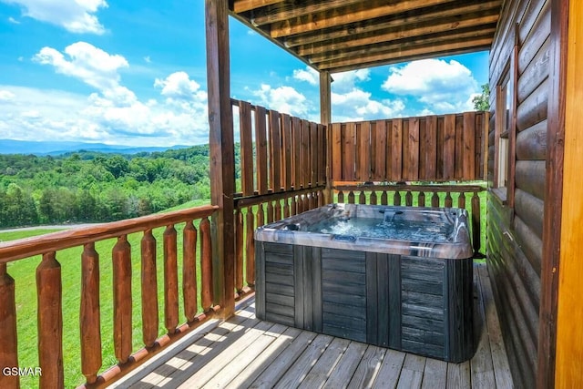 wooden terrace with a forest view and a hot tub