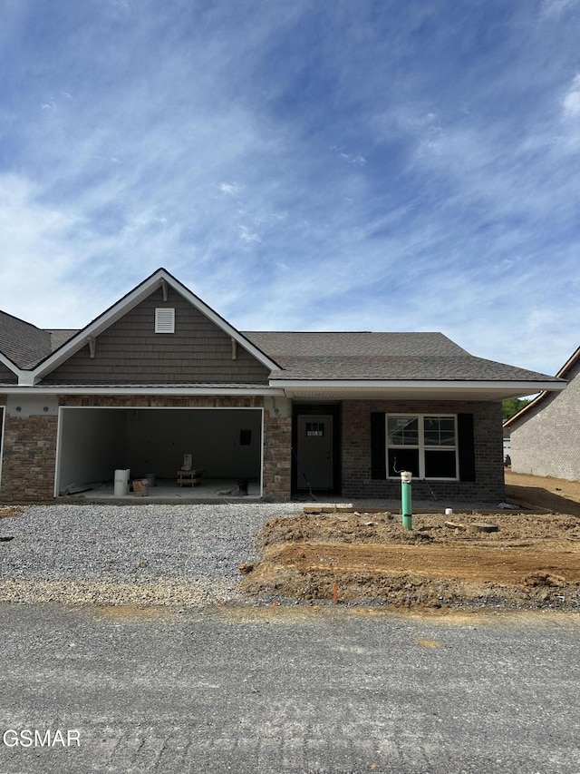 661 Snowflower Cir Unit 144, Pigeon Forge, TN 37863 - view of front of property with an attached garage, gravel driveway, a shingled roof, and brick siding