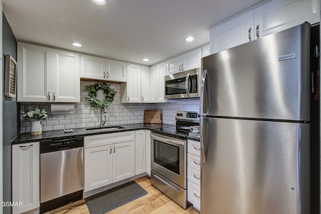 523 Orchard Valley Way Unit 432, Sevierville, TN 37862 - kitchen with stainless steel appliances, white cabinets, tasteful backsplash, dark stone counters, and light wood-style flooring