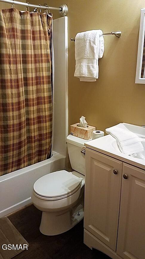 full bathroom featuring vanity, shower / bathtub combination with curtain, and toilet