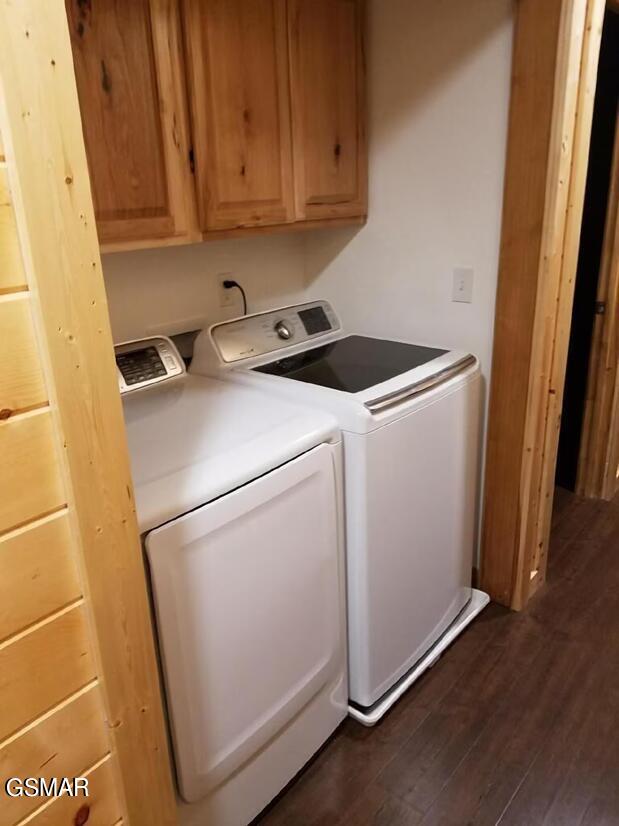 laundry area featuring cabinets, dark hardwood / wood-style flooring, and independent washer and dryer