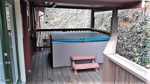 wooden deck featuring a hot tub