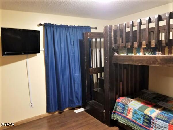 bedroom with hardwood / wood-style floors and a textured ceiling