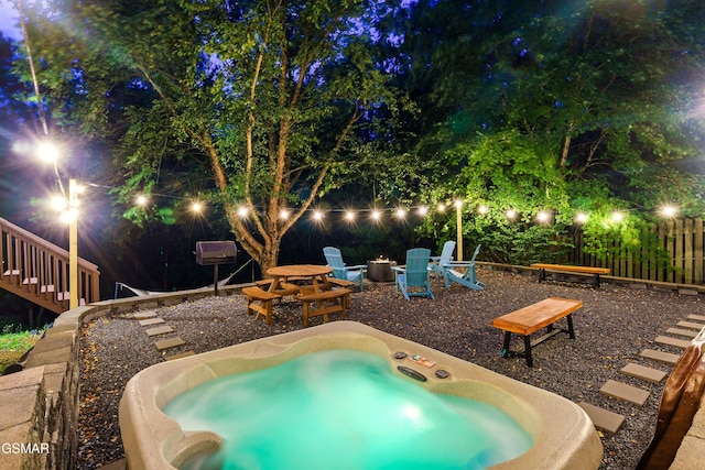 3230 Cove Creek Way, Sevierville, TN 37862 - pool at night with stairs, a fire pit, fence, and an outdoor hot tub