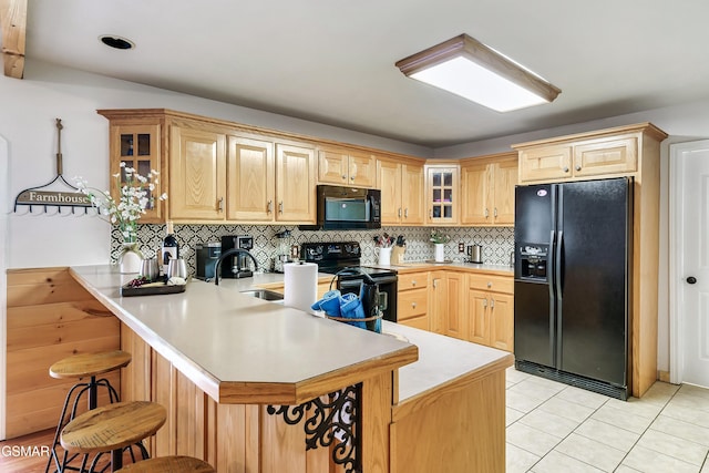 3230 Cove Creek Way, Sevierville, TN 37862 - kitchen with black appliances, light countertops, a peninsula, glass insert cabinets, and light brown cabinetry