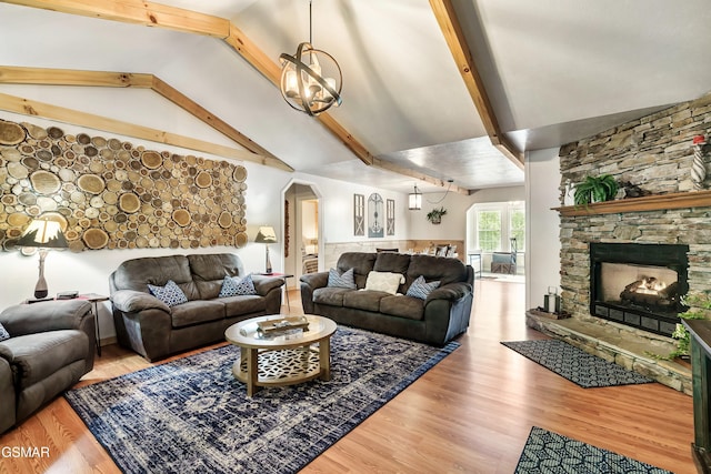 3230 Cove Creek Way, Sevierville, TN 37862 - living area featuring beam ceiling, wood finished floors, arched walkways, a stone fireplace, and a chandelier