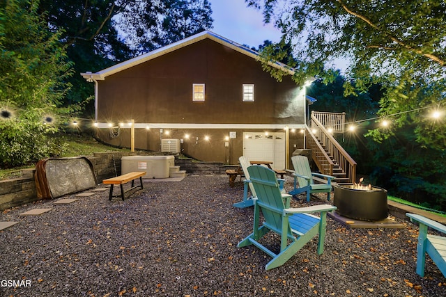 3230 Cove Creek Way, Sevierville, TN 37862 - back of house featuring an outdoor fire pit, stairs, a garage, stucco siding, and a wooden deck