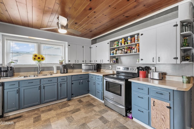 kitchen featuring open shelves, blue cabinetry, a sink, stainless steel appliances, and light countertops