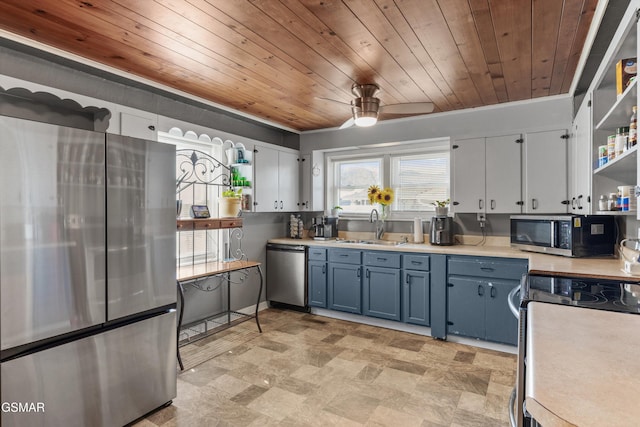 kitchen featuring open shelves, blue cabinetry, a sink, appliances with stainless steel finishes, and light countertops