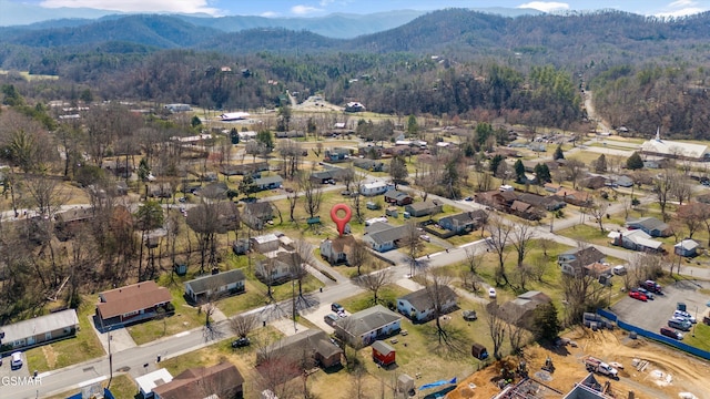 drone / aerial view featuring a view of trees, a mountain view, and a residential view