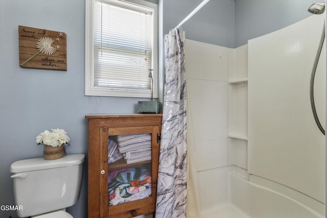 bathroom with toilet and a shower with shower curtain