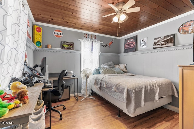 bedroom featuring crown molding, wood finished floors, wood ceiling, and a wainscoted wall