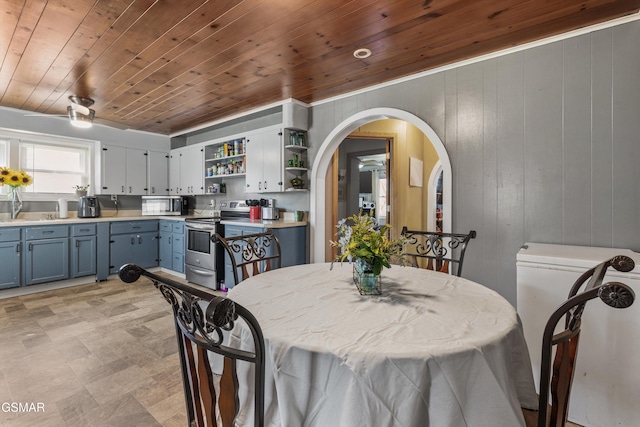 dining space featuring wooden ceiling, arched walkways, and wood walls