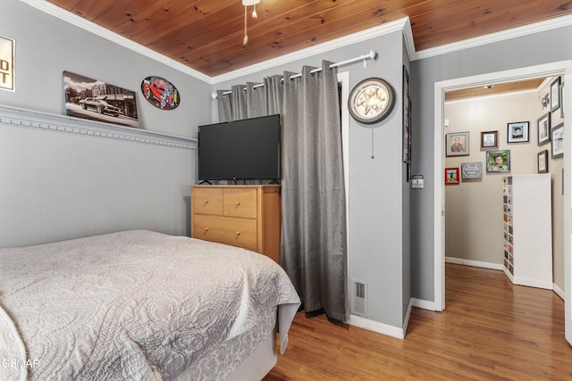 bedroom featuring visible vents, wood ceiling, wood finished floors, and ornamental molding