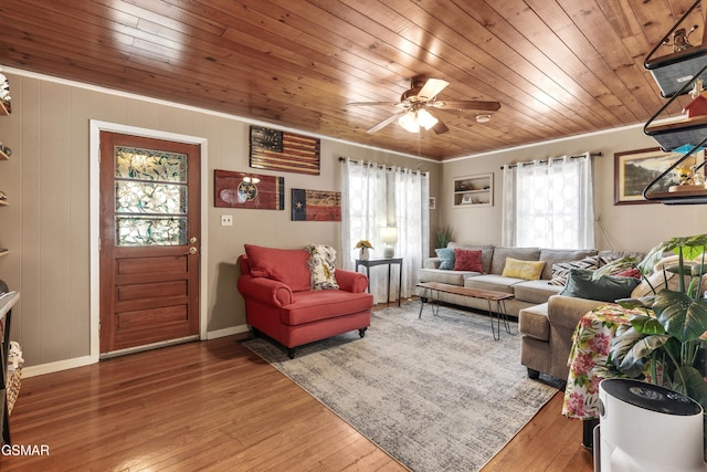 living room featuring wooden ceiling, baseboards, wood-type flooring, and ornamental molding